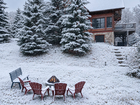 Snowy fire pit lounge with forest views and cozy cabin charm