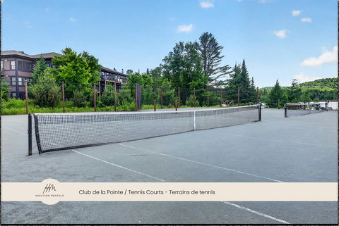 Scenic on-site tennis courts surrounded by trees and mountain views