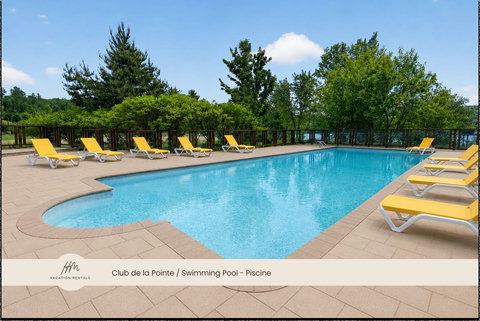 Sunny outdoor pool with lounge chairs in a peaceful, tree-lined setting