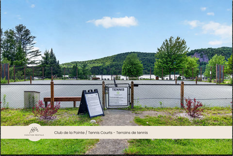 Scenic outdoor tennis courts surrounded by lush trees and mountain views