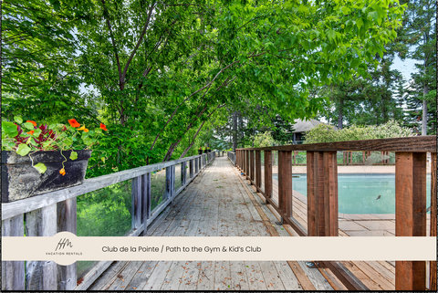 Tree-lined boardwalk path to the pool, gym, and kids’ club