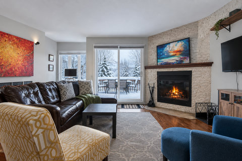Cozy fireplace lounge with snowy view balcony and mountain charm