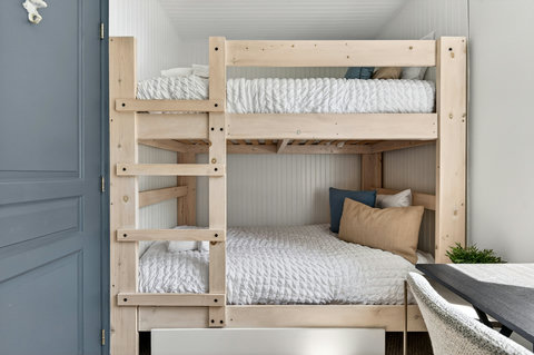 Cozy custom bunk room with stylish wood beds and a handy desk nook
