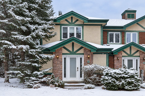 Charming snow-covered retreat with lodge-style curb appeal