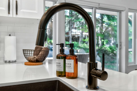 Bright modern kitchen with sleek black faucet and garden views