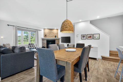 Bright open dining and living area with fireplace and large picture window