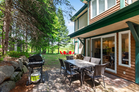 Private wooded patio with grill, outdoor dining, and cozy firepit seating
