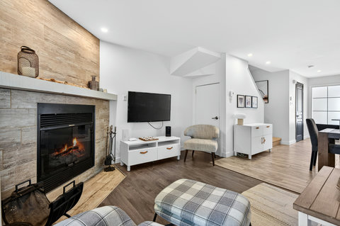 Cozy modern living room with fireplace, TV, and bright open layout