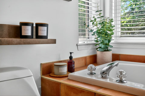 Bright spa-like bathroom with natural light and warm designer touches