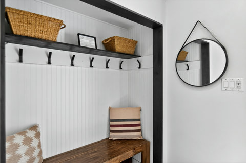 Chic entryway mudroom with bench seating, hooks, and woven storage
