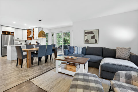 Bright open living space with cozy sectional and garden-view patio doors