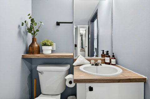 Modern powder room with warm wood accents and thoughtful guest touches