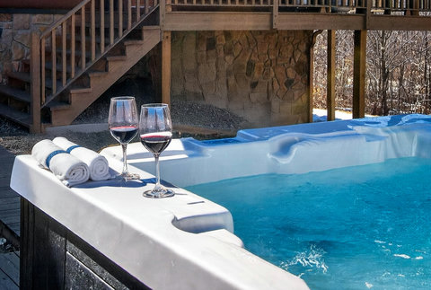 Private outdoor hot tub beneath rustic deck—soak with forest views