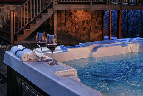 Private outdoor hot tub by the cabin—romantic soak with forest views.