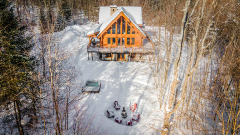 Secluded log cabin with hot tub, fire pit, and snowy forest views