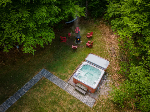 Private wooded hot tub retreat with fire pit, hammock, and Adirondack chairs