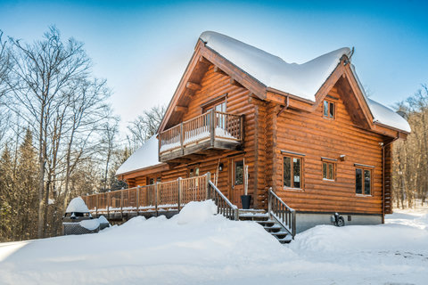 Cozy log cabin retreat with snowy views, deck, and private balcony