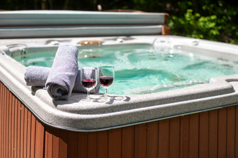 Private outdoor hot tub with towels and wine for a relaxing retreat