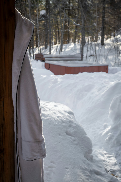 Snowy path to a private outdoor hot tub in a peaceful forest setting