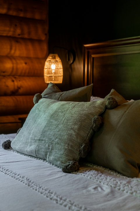 Cozy cabin-style bedroom with warm lighting and plush layered bedding