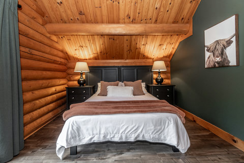 Cozy rustic bedroom with vaulted wood ceilings and warm cabin charm
