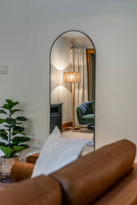 Arched mirror and cozy lounge corner with warm, stylish decor