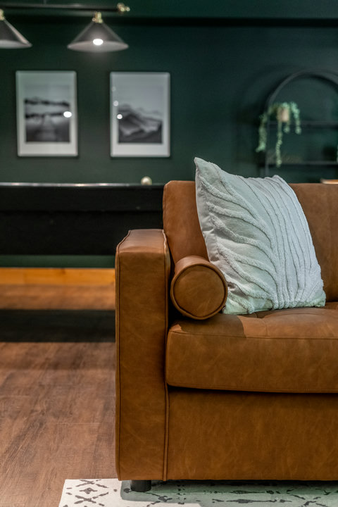 Cozy designer lounge with leather seating and rich, moody decor