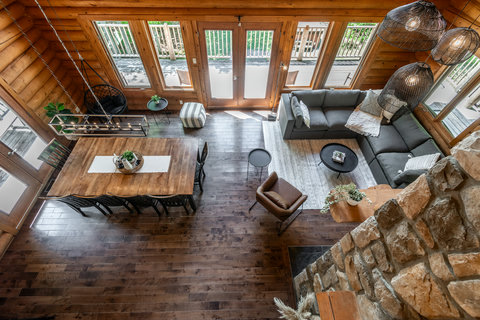 Bright rustic great room with deck access, dining space, and cozy sectional