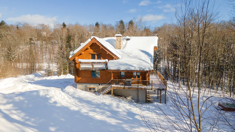 Cozy log cabin retreat with snowy views and a spacious wraparound deck