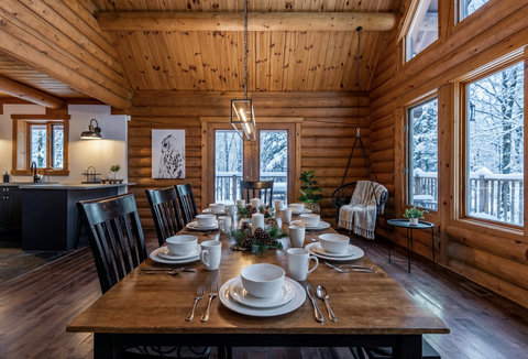 Rustic log cabin dining with snowy forest views and cozy gathering space