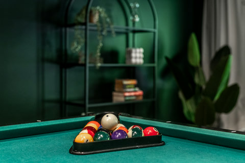 Stylish game room with pool table, rich green decor, and inviting lounge vibes