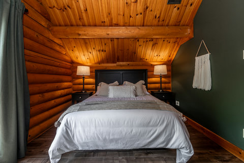 Cozy rustic bedroom with vaulted wood ceilings and warm cabin charm