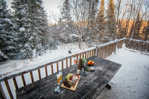 Scenic snowy deck with forest views and a cozy outdoor dining setup