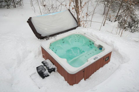Private outdoor hot tub surrounded by snow for the ultimate winter soak