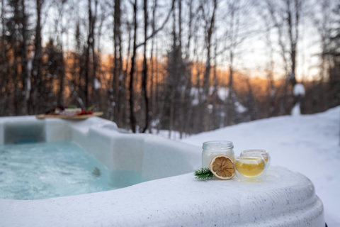 Soak in the outdoor hot tub with snowy forest views and cozy winter vibes