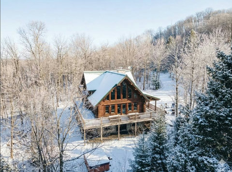 Cozy log cabin retreat with panoramic windows and serene snowy views