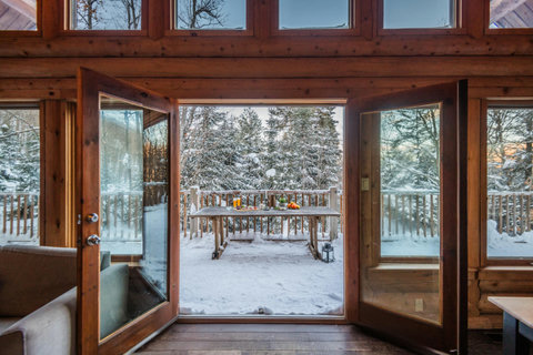 Open the doors to a private snowy deck and serene forest views