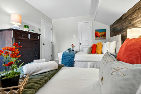 Bright twin bedroom with cozy linens, wood accent wall, and ample storage