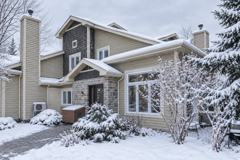 Charming snowy retreat with stone accents and bright picture windows