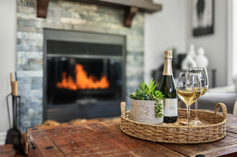 Cozy living room with stone fireplace—wine-ready for fireside evenings.