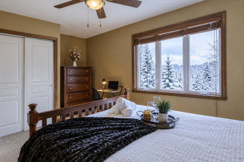 Cozy bedroom with snowy views, workspace, and warm cabin-style charm