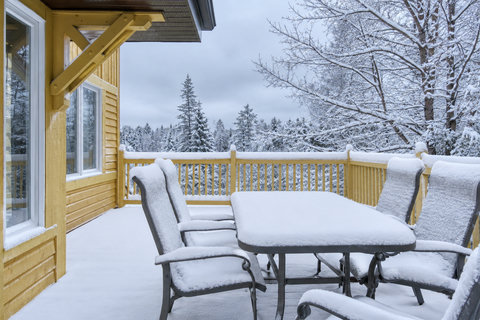 Snowy private deck with outdoor dining and serene winter forest views