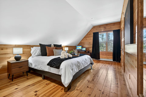 Cozy cabin bedroom with forest views, desk, and smart TV