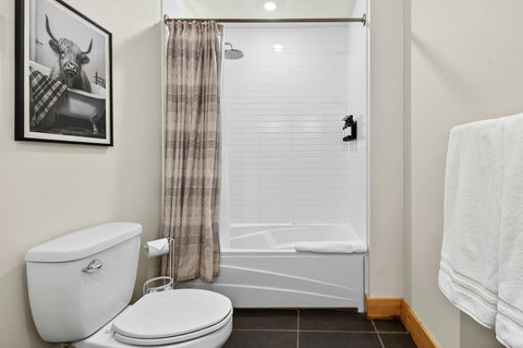 Bright bath with tub/shower, rain head, and fresh white towels