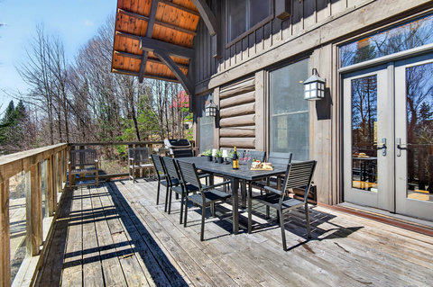 Spacious forest-view deck with dining for 8, grill, and French doors