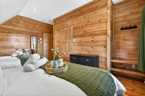 Cozy twin-bed cabin room with pine walls, fresh linens, and rustic charm