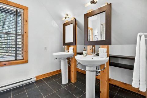 Dual-sink cabin bath with slate floors and warm wood accents