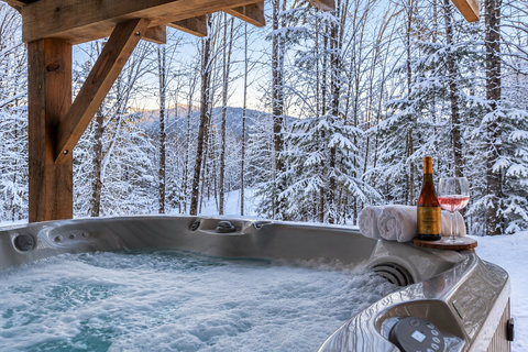 Private covered hot tub with snowy forest views and après-ski ambiance
