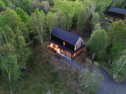 Set on a large private lot, the living room features soaring floor-to-ceiling windows with unobstructed forest views — a peaceful escape with total privacy. Taken 05/2025