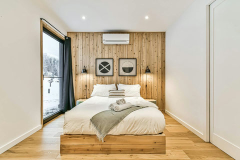 Primary Bedroom - Retreat to the main-floor primary suite, complete with a queen bed, private ensuite, blackout drapes, and a heat pump for customized heating and cooling.